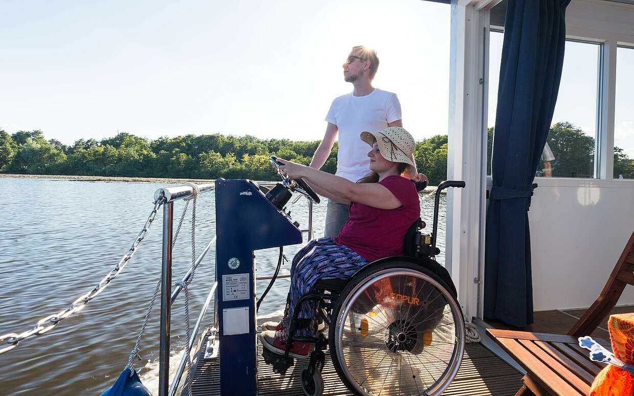 Rollstuhlfahrerin auf Hausboot