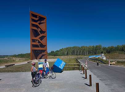 Radfahrer an der Landmarke Rostiger Nagel am Sedlitzer See